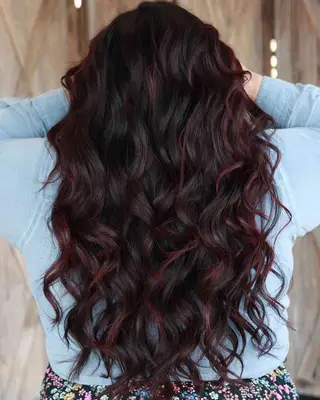 Black hair with red, burgundy ribbons styled in curls