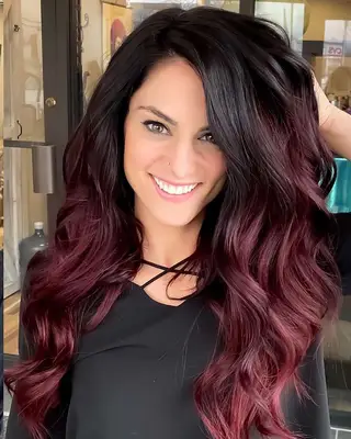 Long hair styled in loose curls and colored burgundy