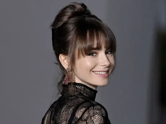 Lily Collins in an updo and bottleneck bangs