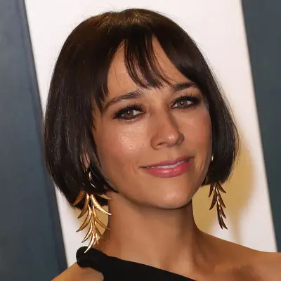 Rashida Jones wears a jaw-length bob with bangs and gold leaf earrings at the 2020 Vanity Fair Oscar Party in Beverly Hills, California