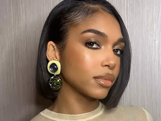 Lori Harvey in full glam with gold statement earrings and a bob