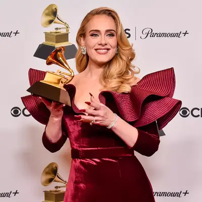 adele posing with her grammy award