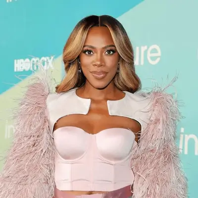 Yvonne Orji with center parted dirty blonde waves