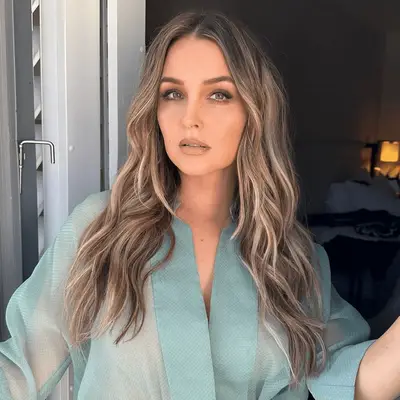 Camilla Luddington with dark-toned wavy dirty blonde hair and blue jacket