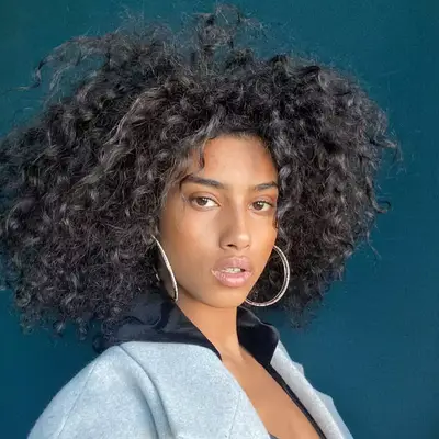 Woman with curly hair and silver highlights