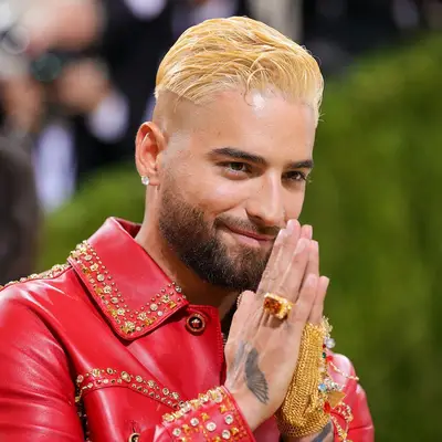 Maluma wears bleached, slicked back hair with an undercut