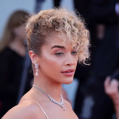 Jasmine Sanders with a curly French Twist hairstyle with bangs