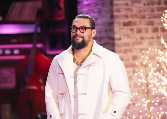 jason momoa in white jacket and glasses with gold chain