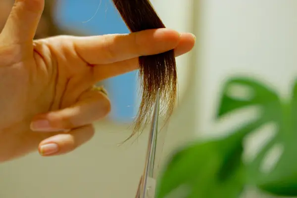 woman cutting the ends of her hair