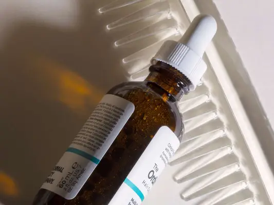 Minioxidil and a comb on a white background