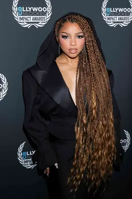 Chloe Bailey in a hooded black ensemble with copper crinkly box braids