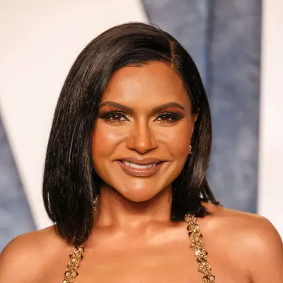 Mindy Kaling wears a sleek, face-framing bob hairstyle with side part