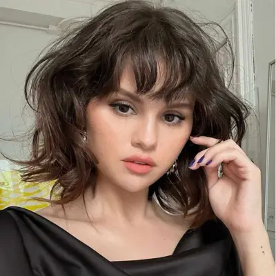 Selena Gomez with bangs and a wispy bob.