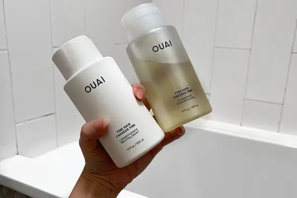 Ouai Shampoo + Conditioner for Fine Hair bottles in hand