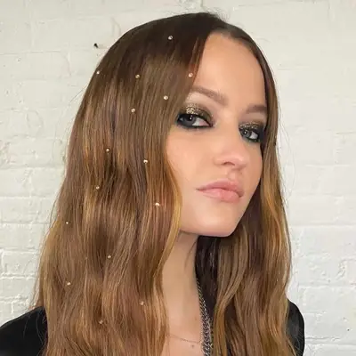 Megan Puleri wears light, relaxed waves with scattered rhinestones throughout