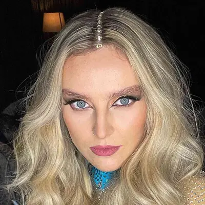 Perrie Edwards wears full messy waves with large gems down her center parting