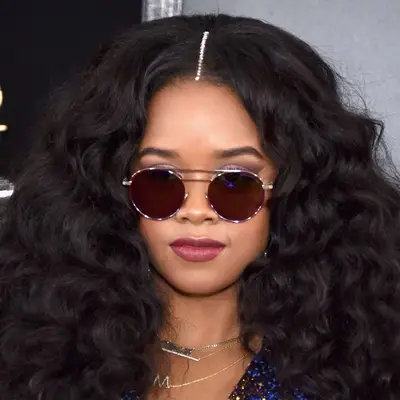 H.E.R. wears a line of jewels down her center part