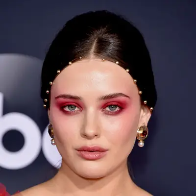 Katherine Langford wears gold beads spaced out along her hairline at the AMAs