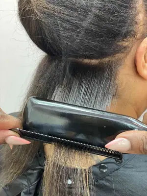 Use a heat-resistant comb alongside your flat iron