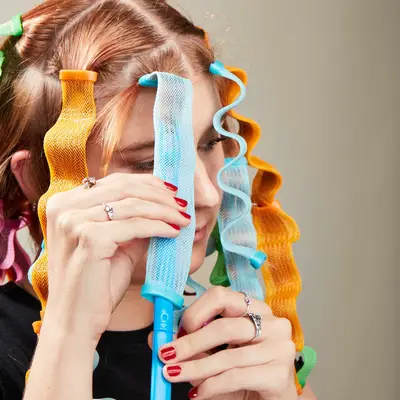 MYM Beauty editor Bella Cacciatore pulling a section of her hair through a waveformer with a hook