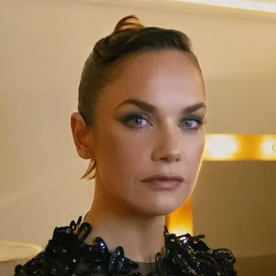 Ruth Wilson with a slicked back hair with a swoop pouf.