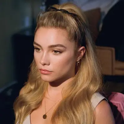 A close up of Florence Pugh with a 2000s style hair pouf, secured in a black ribbon bow.