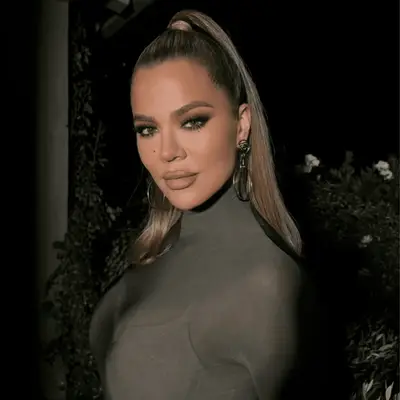 Khloe Kardashian in a slicked back ponytail and straight hair.