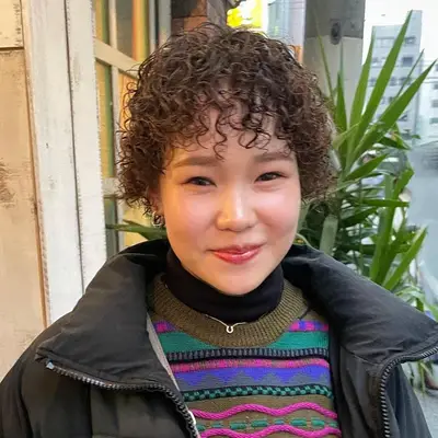 woman with short spiral perm with bangs