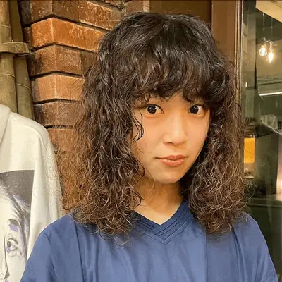 woman with bangs and spiral perm