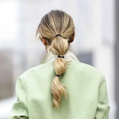 back of woman with blonde hair in low bubble ponytail
