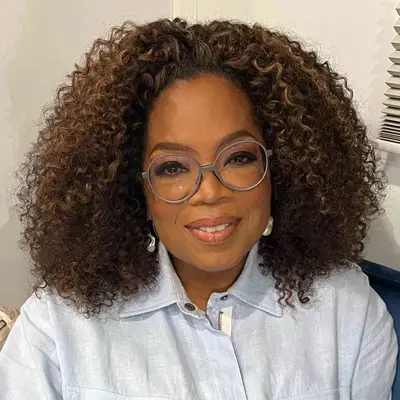 Oprah Winfrey wears a naturally curly long bob hairstyle