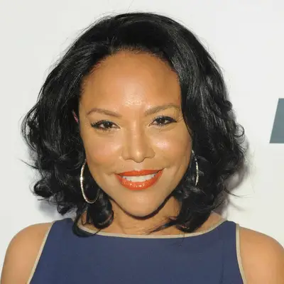 Lynn Whitfield wears a blown-out bob hairstyle with oversized hoop earrings
