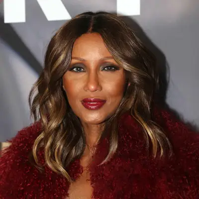 Iman wears a curled long bob hairstyle with face-framing highlights