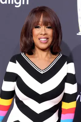 Gayle King wearing a red bob with bangs