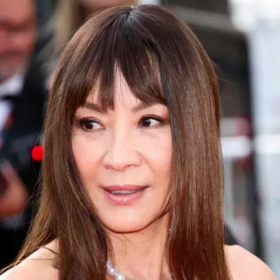 Michelle Yeoh with long brown hair and full fringe at the 