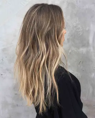 Side view of person with long blonde balayage highlights 
