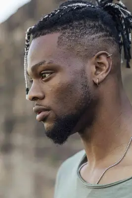 Man wearing viking braids going straight back with faded sides