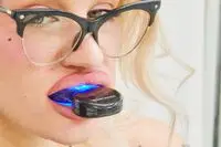 Closeup of a person putting the Periosciences LED 2 Teeth Whitening Kit mouthpiece into their mouth