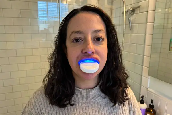 A person uses the HeySmile Teeth Whitening Kit