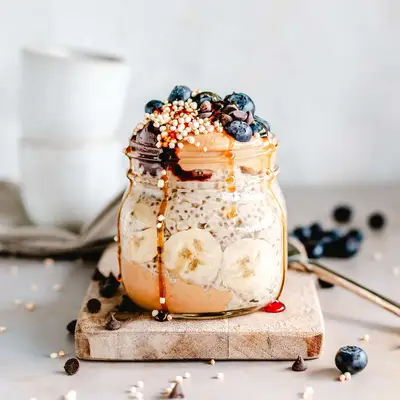Overnight oats in a jar with banana, blueberries, and peanut butter