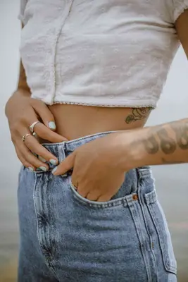 woman wearing crop top and jeans