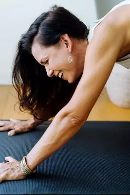 closeup of person laughing in down dog yoga pose