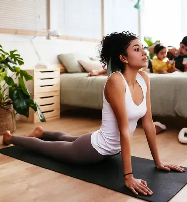 person does upward facing dog yoga pose at home