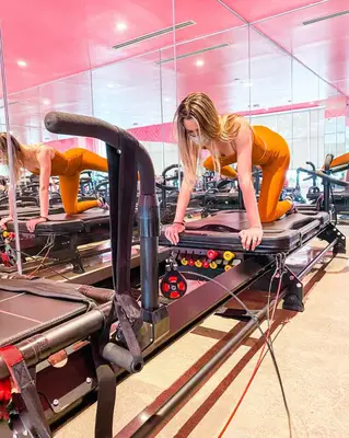 person using pilates megaformer machine