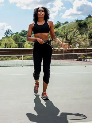 person walking with tennis racquet on court