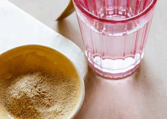 pink glass of water next to collagen powder