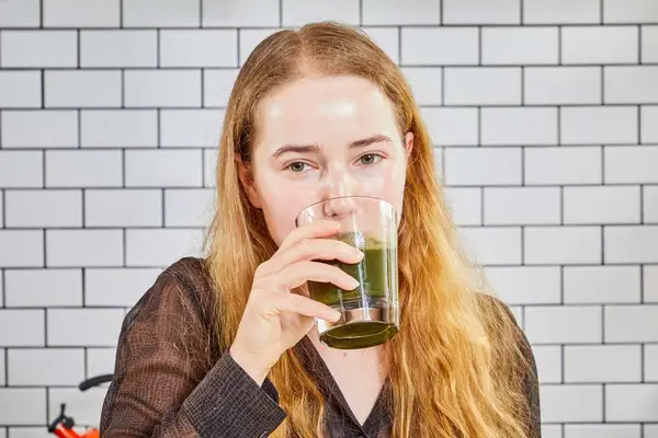 Person drinking Amazing Grass Greens Blend Superfood