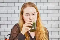 Person drinking Amazing Grass Greens Blend Superfood