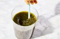 Straw in a glass of Ancient Nutrition Organic SuperGreens