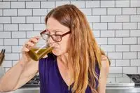Woman drinks Dr. Mercola Fermented Greens Powder